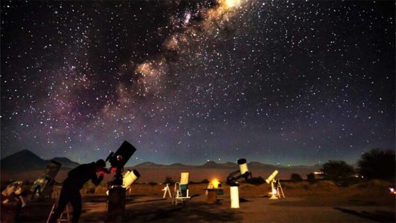 Homem observando o ceu do deserto no tour astronomico